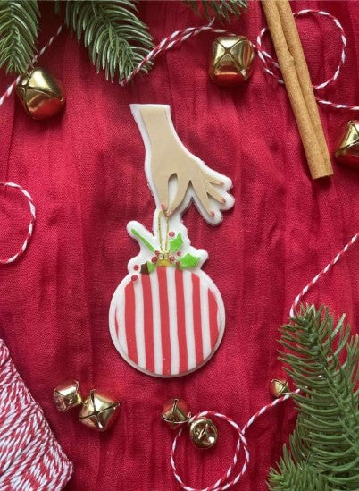 Hand holding Bauble cookie cutter and stamp