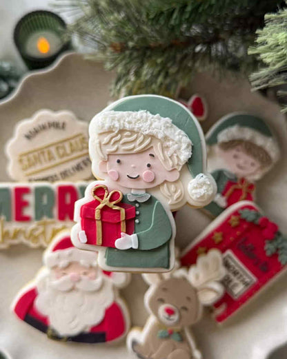 Girl holding present cookie cutter and stamp